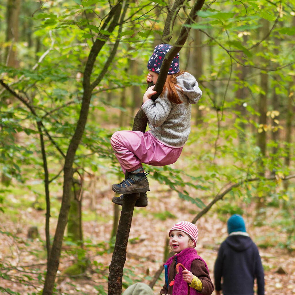Gemeinsam spielende Kinder, kletterndes Kind